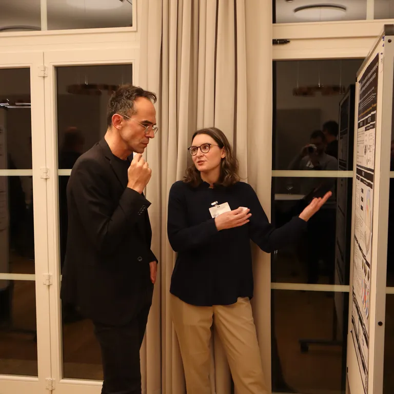 two people talking in front of flipchart with data on it